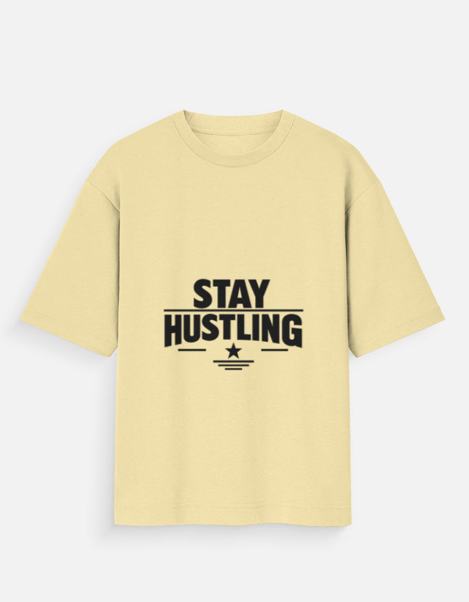 Oversized crew-neck T-shirt in beige, short sleeves, front graphic text “STAY HUSTLING”
